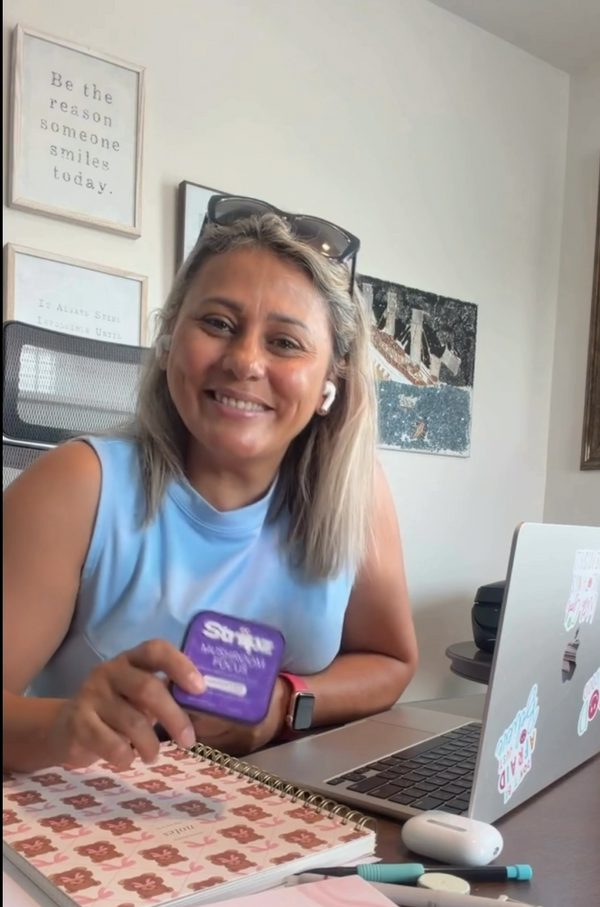 Woman working at a desk with Striipz Mushroom Focus chocolate-flavored supplement beside her laptop